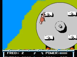 Fred grabs onto a platform of the rotating wheel