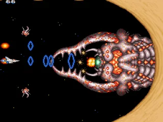 In a cosmic sand field, Vic Viper uses its Ripple Beam to beat the menace called Earwig Scorpion.